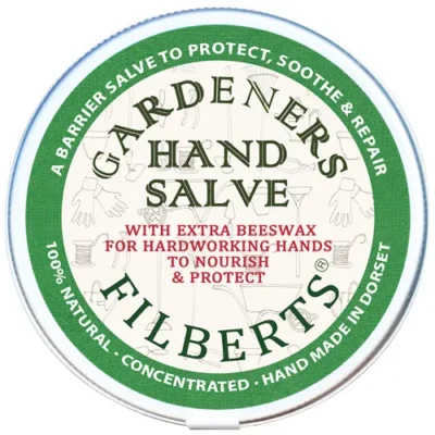 Gardeners Hand Salve flat lay image of 40g tin on white background. Label has a green border with the following background: 'A barrier salve to protect, soothe & repair. 100% Natural. Concentrated. Hand Made in Dorset. Gardeners Hand SAlve with extra beeswax for hardworking hands. To nourish & protect.'